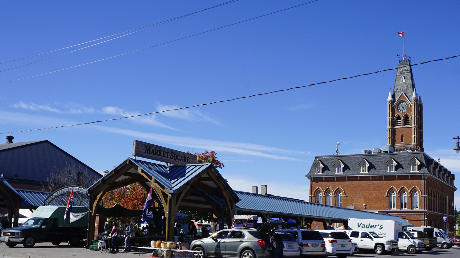 People and market stalls in Belleville Market Square beside City Hall